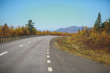 Beautiful vibrant fall autumn landscape of national park near border of Finland, Sweden and Norway, with mountains, camping place, road and forest