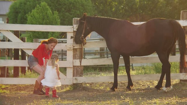 Mom with daughter petting a horse