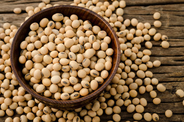 Soybean in wood bowl on wooden background.