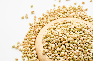 Uncooked buckwheat in wooden dish.