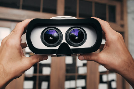 Virtual reality glasses with image inside. Hands holding vr goggles with picture of movie to watch. Modern technology, innovation, cyberspace, entertainment concept