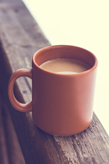 A cup with a hot drink on the background of the winter forest