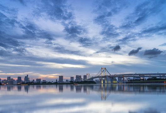 cityscape and skyline of tokyo from water at sunset