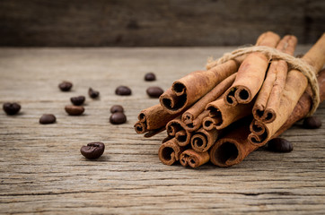 Cinnamon sticks and coffee grains on old rustic background, seasoning ingredients for cooking or baking.