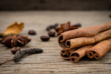 Cinnamon sticks, star anise turmeric and coffee grains on old rustic background, seasoning ingredients for cooking or baking.