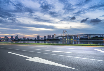cityscape and skyline of tokyo at sunset from empty road