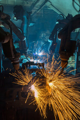 Team robot welding automotive part in production line