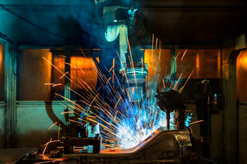 Robot welding automotive part in factory