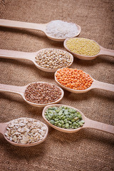 Groats in spoons on burlap