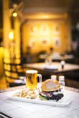 cheese and bacon gourmet beef burger with fries and beer