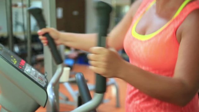 Woman trains on stepper machine in gym. Concept of health and fitness.