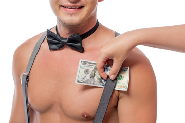 female hand puts dollars under the strap suspenders strippers