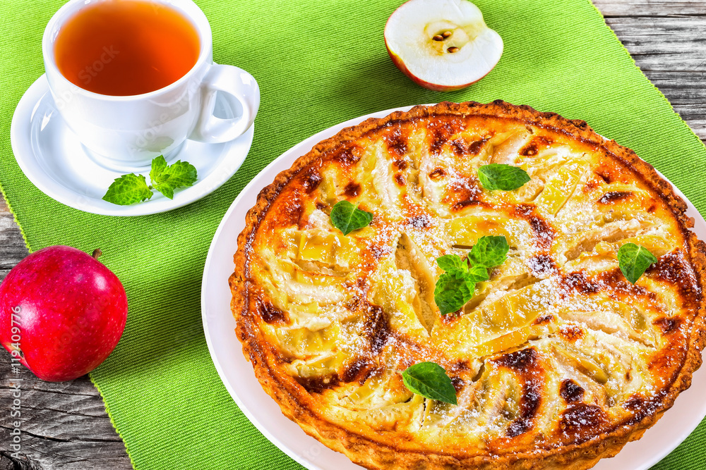 Sticker apple pie sprinkled with icing sugar decorated with mint leaves