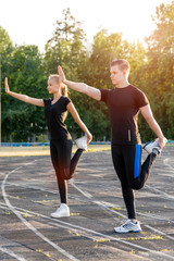 Cute healthy couple in warming up outdoors