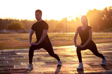 Silhouettes of young sporty man and woman outdoors