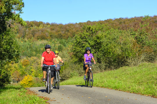 Drei gutgelaunte Seniorinnen machen eine Radtour im Herbst