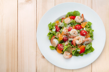 Grilled shrimp salad on wood table, Top view
