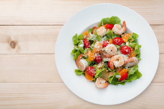 Grilled shrimp salad on wood table, Top view