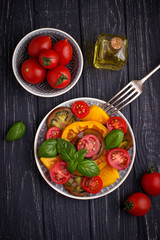 Colorful tomatoes salad in black background