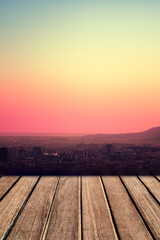 Naklejka na ściany i meble Old wooden table in front of sunset sky as background. Vintage p