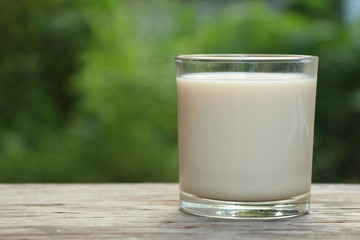 milk in grass on wood table.