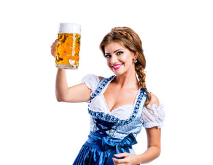 Woman in traditional bavarian dress holding mug of beer