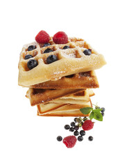 Wide angle view of stacked waffles with raspberries and blueberries isolated