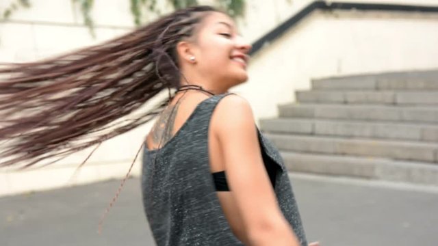 Girl shakes her dreadlocks and smile