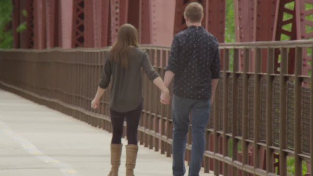 Young couple walking along a bridge