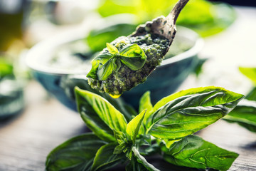 Fototapeta premium Fresh basil leaves pesto on wooden table.