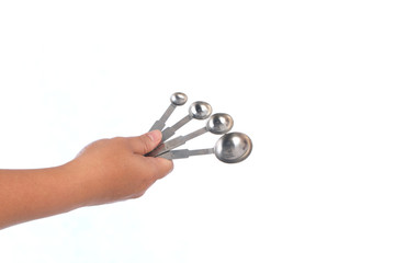 hand hold steel measuring spoons on white background,selective focus