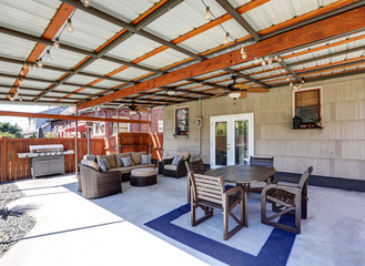 Covered back deck with concrete floor and outdoor furniture.