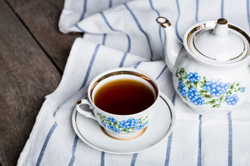 still life with tea cup and tablecloth on wooden table