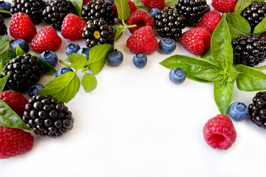Various fresh summer berries. Ripe blueberries, raspberries and blackberries. Berries on white background. Top view with copy space.