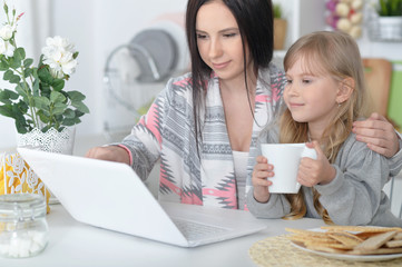 mother and daughter using laptop