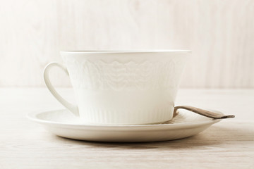 Taza blanca sobre un fondo de madera claro rústico. Vista de frente y de cerca