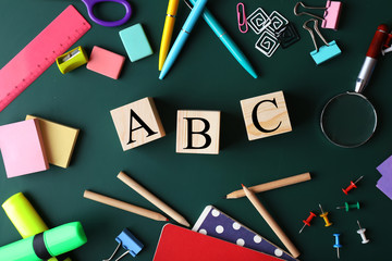 Composition of colourful stationery and word ABC on chalkboard