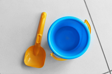 Children bucket and shovel on tile floor