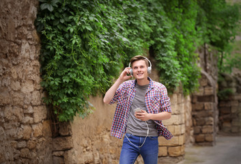 Handsome man listening music on street