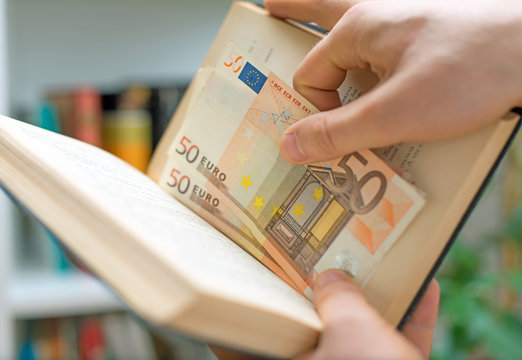 Man Hiding Money In A Book. Secret Stash Place.