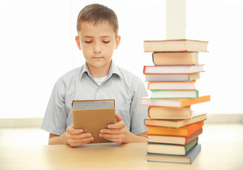 Fototapeta na wymiar Boy with many books at school