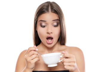 Beautiful young woman drinking coffee on white background