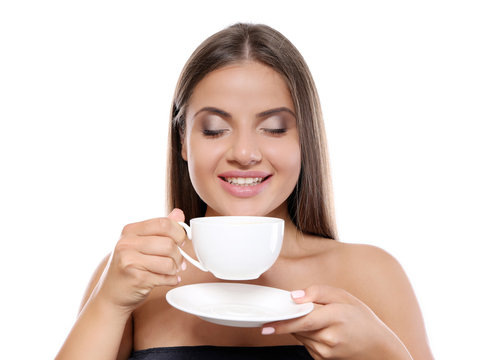 Beautiful young woman with cup of coffee on white background