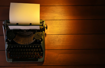 Typewriter on wooden background, top view