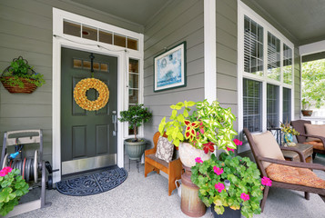 Cozy entrance porch with flower pots and seating arrangement