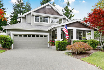 Fototapeta na wymiar Nice curb appeal of grey house with covered porch and garage
