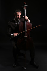 Man playing cello in darkness