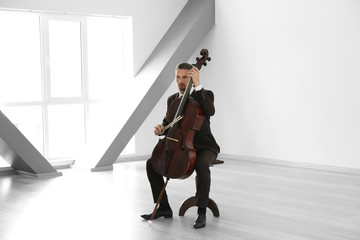 Man playing cello in room