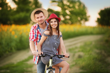 Young couple on bicycle in field