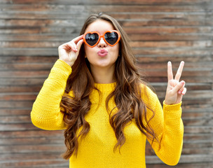 Beautiful smiling brunette woman in sunglasses blowing lips kiss
